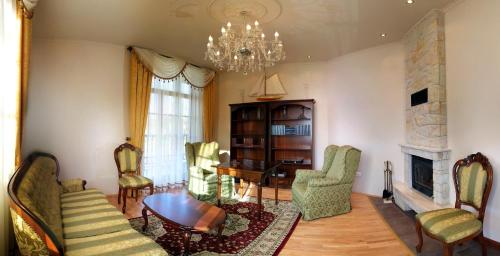 a living room with a fireplace and a chandelier at Cztery Pliszki in Gródek Nad Dunajcem
