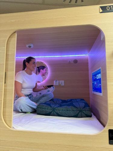 two women sitting on a bed in a small room at BeHome Boulevard in Gold Coast