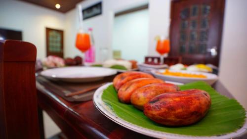 a table with plates of food on a table at Dambullu Dreams Stay in Dambulla