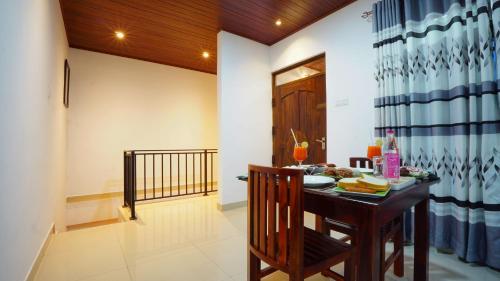 a dining room with a wooden table and a dining room at Dambullu Dreams Stay in Dambulla