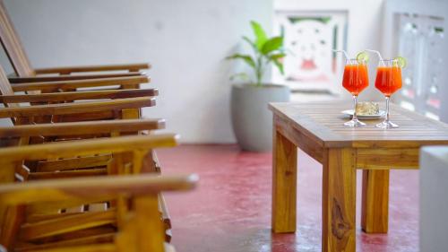 two glasses of red wine sitting on a wooden table at Dambullu Dreams Stay in Dambulla