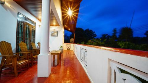 a porch of a house with chairs and a table at Dambullu Dreams Stay in Dambulla