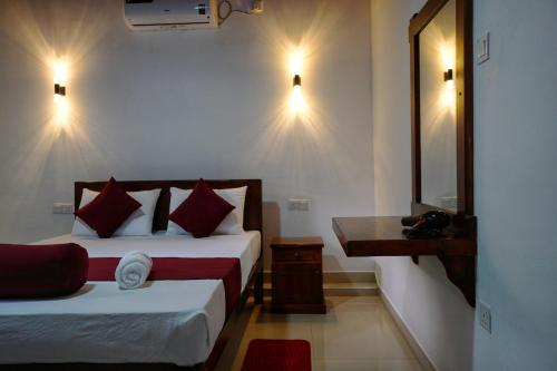 a hotel room with two beds and a mirror at Dambullu Dreams Stay in Dambulla