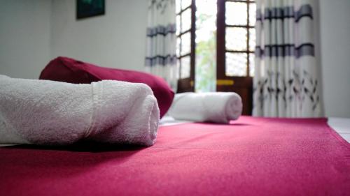 a room with a pink bed with towels on it at Dambullu Dreams Stay in Dambulla
