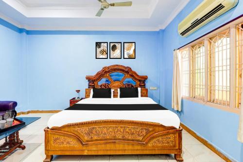 a bedroom with a large bed in a blue room at Hotel O Rayagada Downtown in Rāyagada