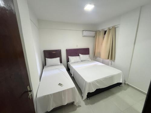 two beds in a small room with a window at Don Julio 1 in Encarnación
