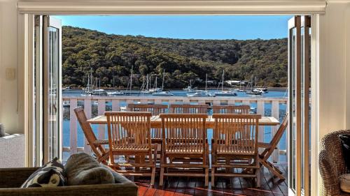 Una mesa y sillas en un balcón con vista al agua. en 'Torcello - Waterfront on the Bay' by HolidayCo, en Hardys Bay