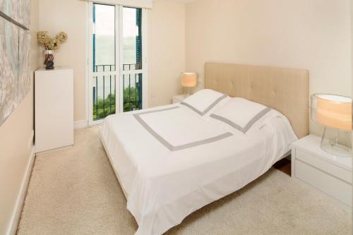 マラガにあるINMálaga Picassoの白いベッドルーム(ベッド1台、窓付)