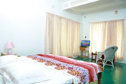 a bedroom with a bed with a blanket on it at Orchid Lake View Homestay in Alleppey