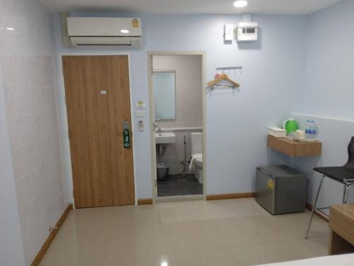 a room with a bathroom with a door and a toilet at Collection O Pratunam 19 Hotel in Bangkok