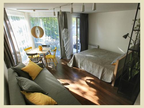 een woonkamer met een bank, een bed en een tafel bij Nora Lemon in Nida