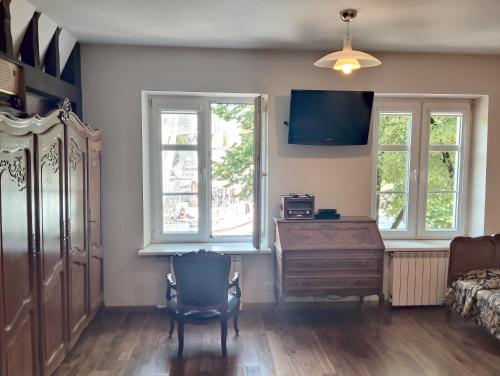 a bedroom with a bed and a dresser and windows at Aparthotel Stora Antis in Klaipėda