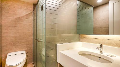 a bathroom with a toilet and a sink and a shower at Oak Valley Resort Valley Village in Wonju