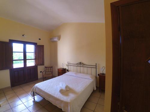 a bedroom with a white bed and a window at Agriturismo SaTanca in Arbus