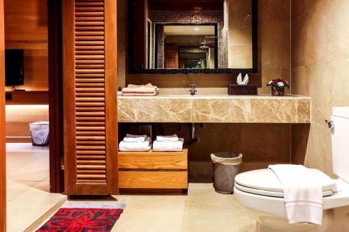 ein Badezimmer mit Waschbecken, Toilette und Spiegel in der Unterkunft The Bonanza Resort Khaoyai in Khanong Phra