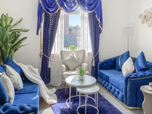 ein Wohnzimmer mit blauen Sofas und einem Tisch in der Unterkunft Amayrah Cottage in Inverness