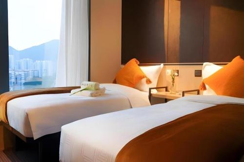 a hotel room with two beds and a window at Ehotel in Hong Kong