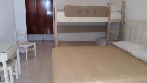 a bedroom with two bunk beds and a desk at Vallian Village Hotel in Paradeísion