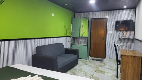 a room with a couch and a green wall at Bell Farms and Resorts in Munroe Island
