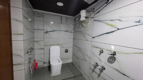 a bathroom with a white toilet in a room at Bell Farms and Resorts in Munroe Island
