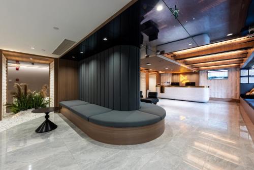 a lobby with a bench in the middle of a room at Leshan Manfu Hotel in Leshan