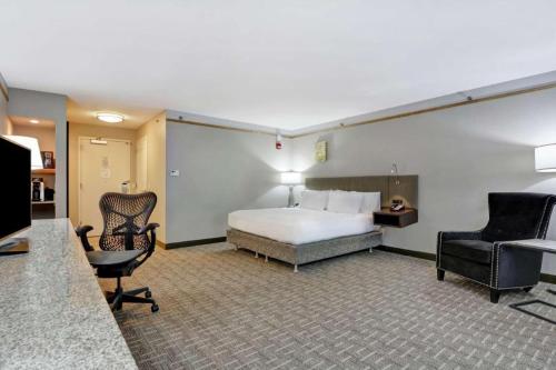a hotel room with a bed and a desk and chairs at Hilton Garden Inn Oshkosh in Oshkosh