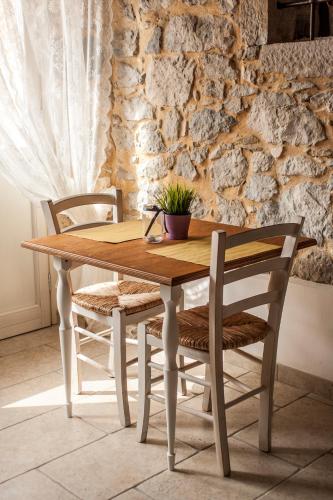 a wooden table with two chairs and a plant on it at Aia Antica in Monte San Biagio