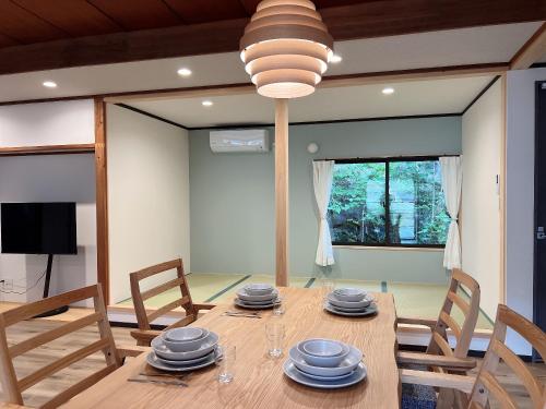 Un comedor con mesa y sillas de madera. en HOTEL DanDan, en Shuzenji