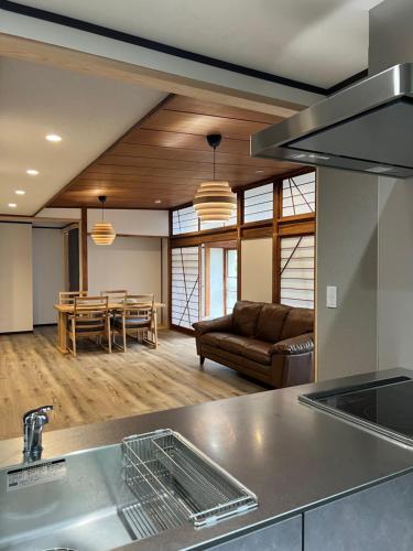 a kitchen and living room with a couch and a table at HOTEL DanDan in Shuzenji