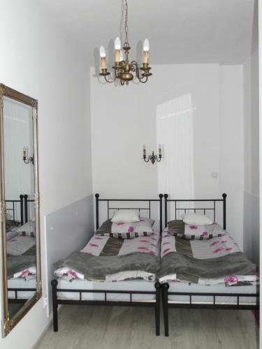 a bedroom with a bed with a mirror and a chandelier at Apartament MARIA in Gdańsk