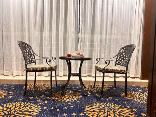 two chairs and a table in front of a window at Zhongshan Hui Quan Hotel in Zhongshan