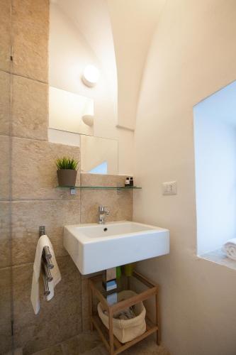a bathroom with a white sink and a mirror at Casaterramare in Ostuni
