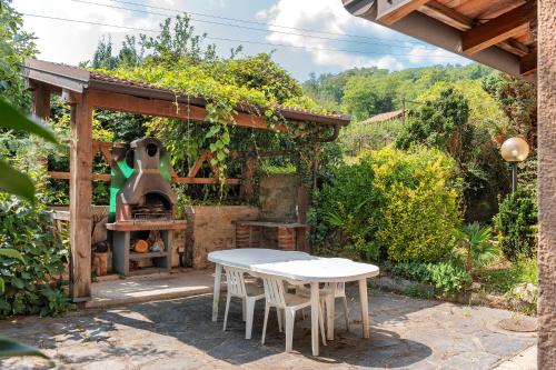 Una cocina al aire libre con una mesa y una estufa. en Unique Lake View In Green Park, en Nebbiuno