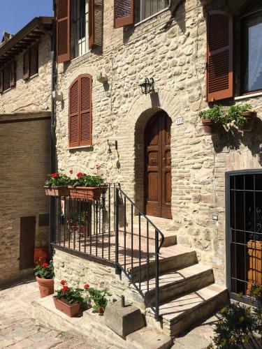 a stone building with stairs and a wooden door at Il Sementone in Assisi