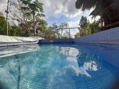 a swimming pool with a reflection of the sky in the water at Casa Rústica Rancho de Lía- Vacacional in Orotina
