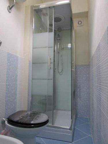 レアルモンテにあるPlaya Dei Turchiのバスルーム(ガラス張りのシャワー、トイレ付)