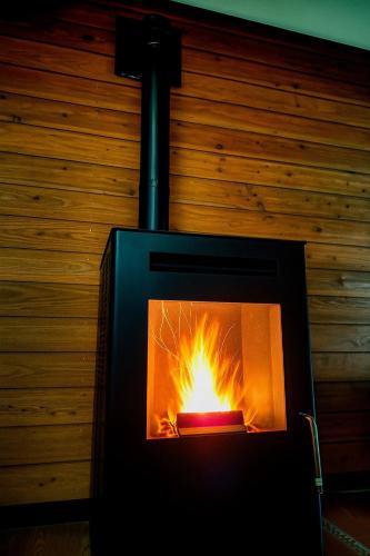 a fireplace with a fire inside of it at 源泉掛け流し温泉付き貸別荘-Private hot spring & Private house! - THE LOOKOUT KUSATSU in Kusatsu