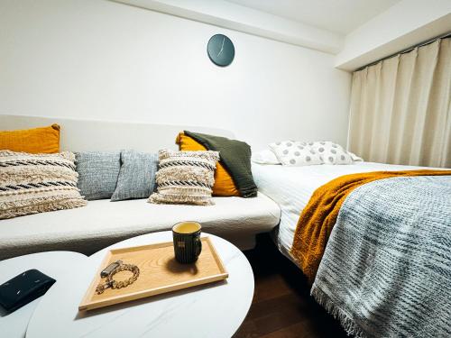 two beds in a room with a table and a couch at sakura 206 in Tokyo