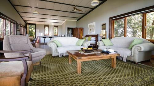 a living room with two couches and a coffee table at Tree Tops Guest Farm in Isidule