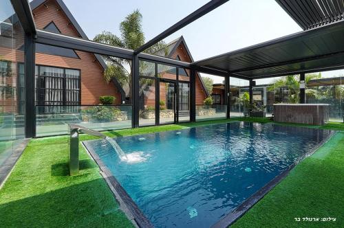 a swimming pool in the yard of a house at Campanga nera - ארבע בקתות מהממות עם בריכה מחוממת וג'קוזי in Yarka