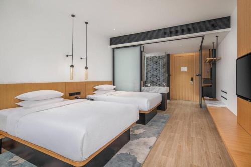 two beds in a hotel room with a tv at Fairfield by Marriott Baoding High-Tech Zone in Baoding