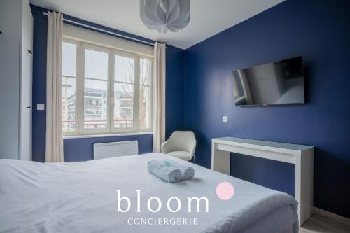 a blue bedroom with a bed and a tv at Le Solignac appartement neuf et tout équipé in Nancy