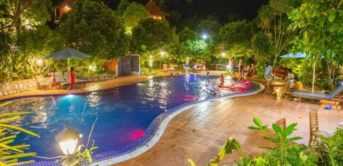 a large swimming pool at night with lights at Legend Kep Resort in Kep