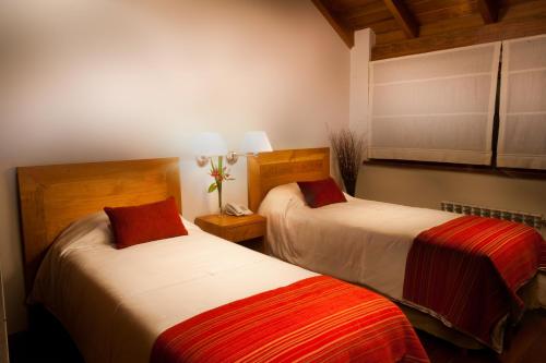 two beds in a hotel room with at Hostería Antares Patagonia by Visionnaire in San Martín de los Andes