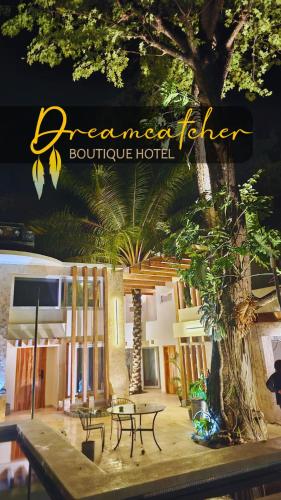 a hotel with tables and trees in front of a building at Dreamcatcher Luxury in Santa Teresa Beach