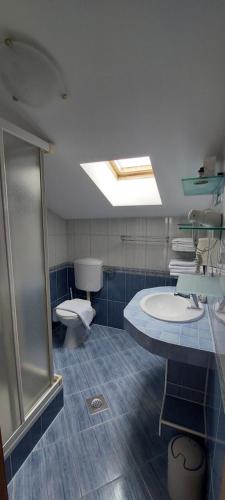 a bathroom with a shower and a sink and a toilet at Apartments Happy Island Rab in Rab