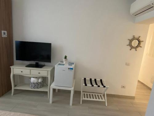 a living room with a television and a white cabinet at Camelia's House in Olbia