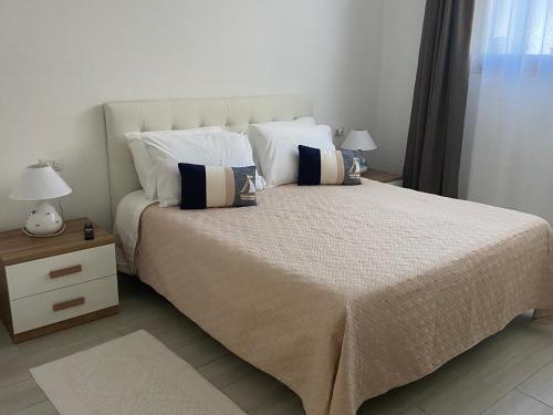a bedroom with a large bed with two lamps at Camelia's House in Olbia