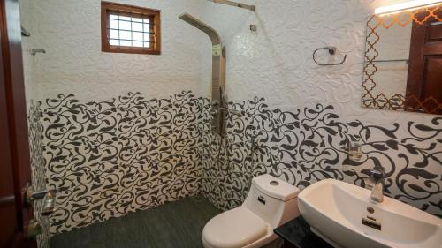 a bathroom with a black and white patterned wall at Badhram Homestay 4bhk in Alleppey
