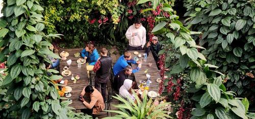 a group of people standing around a table in a garden at Kiwi Backpackers Hostel Pokhara in Pokhara